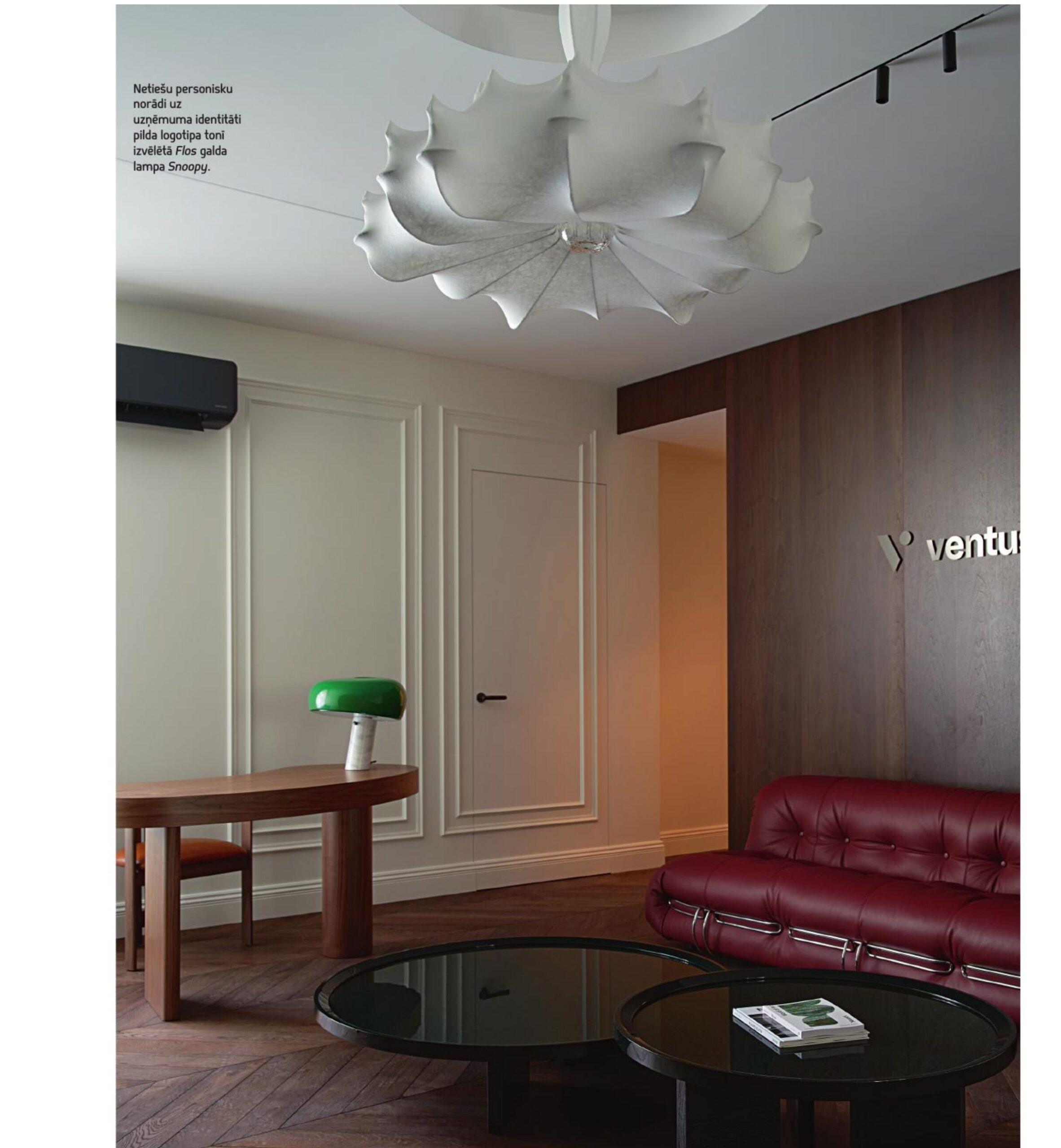 Ventus Energy office: Ventus logo on walnut-paneled wall, Flos Zeppelin pendant lamp, Cassina Soriana burgundy leather sofa, Flos Snoopy green desk lamp, herringbone parquet floor